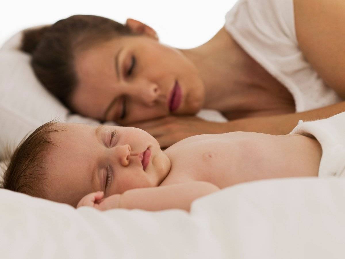 Молодая мама в постели. Совместный сон с ребенком. Мама лежит с малышом. Мама с малышом в кровати.