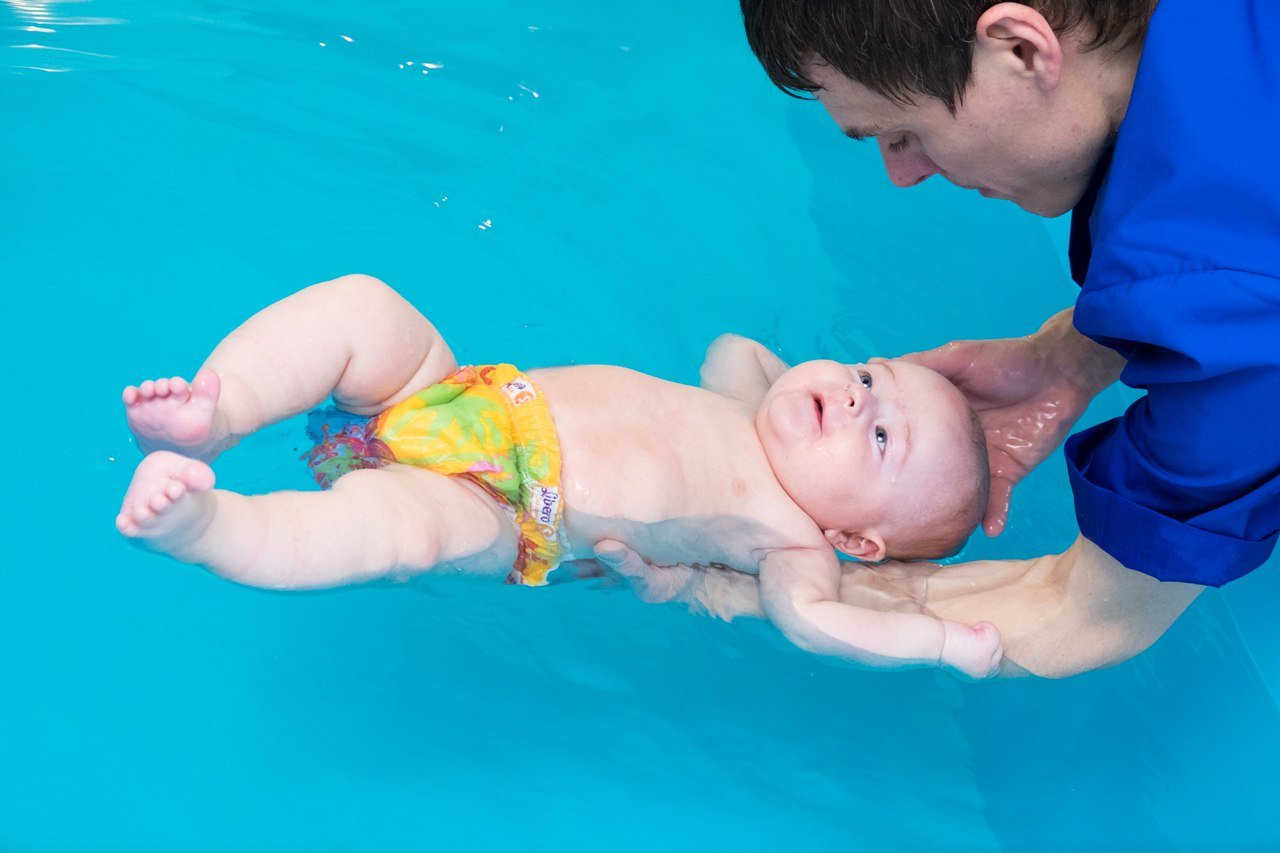 Маленькие купается бассейне. Плавание младенцев. Грудничковое плавание. Грудничковое плавание на спине. Плавание для грудничков.