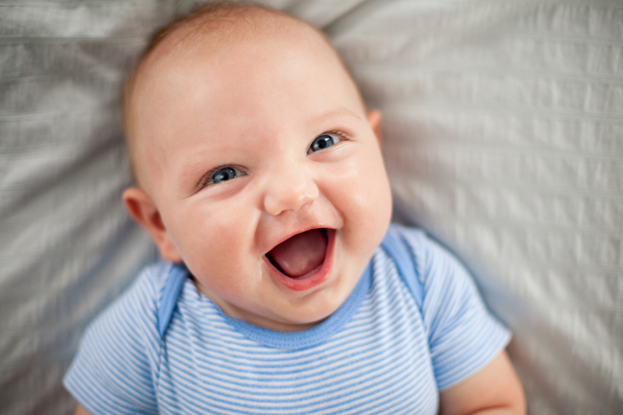 Когда новорожденный улыбается и когда начинает смеяться?